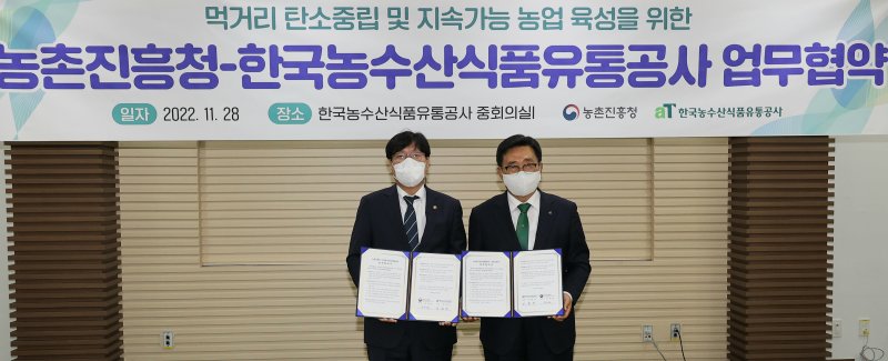 조재호 농촌진흥청장(왼쪽)과 김춘진 한국농수산식품유통공사 사장이 28일 전남 나주혁신도시 한국농수산식품유통공사에서 먹거리 탄소중립 및 지속 가능 농업 육성을 위한 업무협약을 체결하고 있다. (농촌진흥청 제공) 2022.11.28/뉴스1