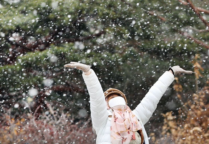 서울을 비롯한 중부 지방에 대설주의보가 내려진 15일 서울 경복궁을 찾은 외국인 관광객들이 내리는 눈을 맞으며 즐거워 하고 있다. 2022.12.15/뉴스1 ⓒ News1 신웅수 기자