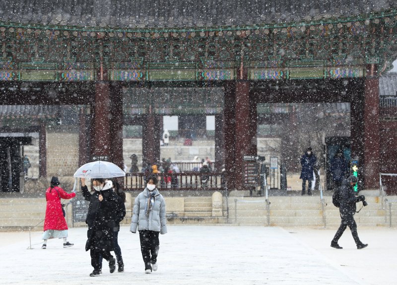 서울을 비롯한 중부 지방에 대설주의보가 내려진 15일 서울 경복궁을 찾은 외국인 관광객 등이 내리는 눈을 맞으며 고궁을 거닐고 있다. 2022.12.15/뉴스1 ⓒ News1 신웅수 기자