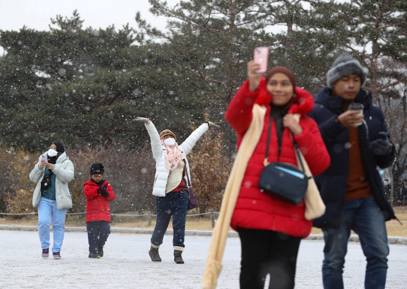 서울을 비롯한 중부 지방에 대설주의보가 내려진 15일 서울 경복궁을 찾은 외국인 관광객들이 내리는 눈을 맞으며 고궁을 거닐고 있다. 2022.12.15/뉴스1 ⓒ News1 신웅수 기자