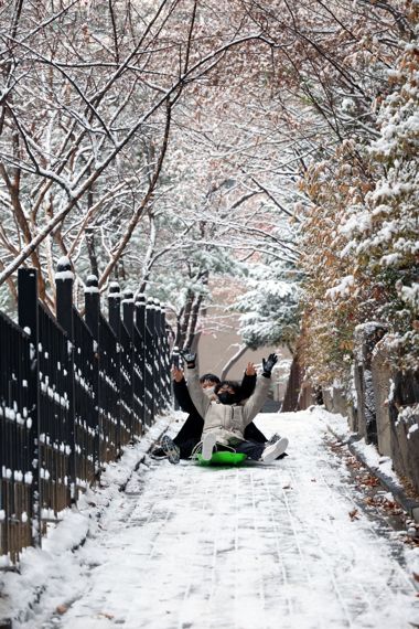 눈썰매 타며 함박 웃음짓는 어린이들