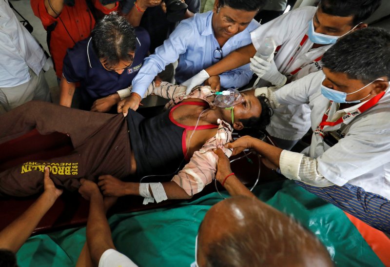 지난 7월 인도 서부 구자라트 주 아마다바드에서 라메쉬바이 라브타(여·32)가 오염된 밀주를 마신 뒤 쓰러져 병원으로 이송되고 있다. 2022.7.26. ⓒ 로이터=뉴스1 ⓒ News1 김성식 기자