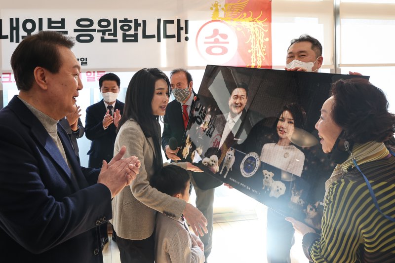 윤석열 대통령과 김건희 여사가 17일 오전 서울 서초구 아크로비스타 사저를 찾아 주민들의 얼굴 사진을 모자이크 해 만든 사진 선물을 받고 있다. (대통령실 제공) 2022.12.17/뉴스1 ⓒ News1 안은나 기자