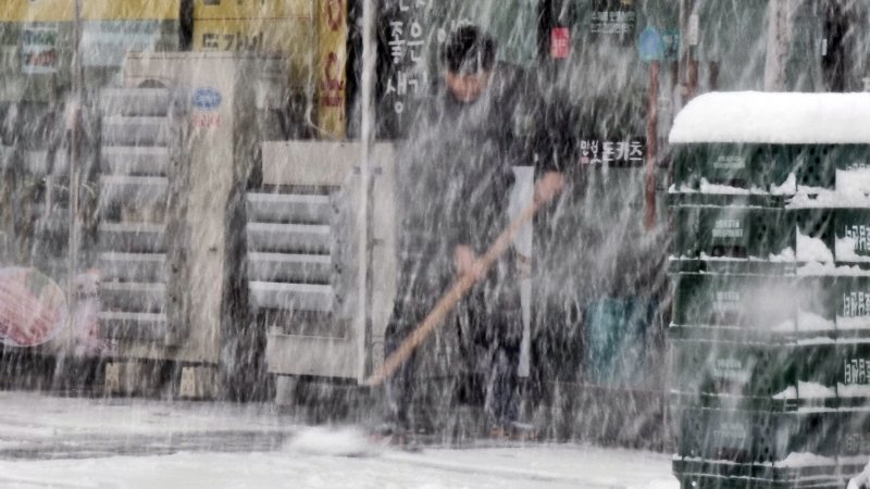 17일 오후 3시30분께 전북 전주시 완산구의 한 상가 앞에서 시민이 가게 앞에 쌓인 눈을 치우고 있다.2022.12.17/뉴스1 ⓒ News1 이지선 기자