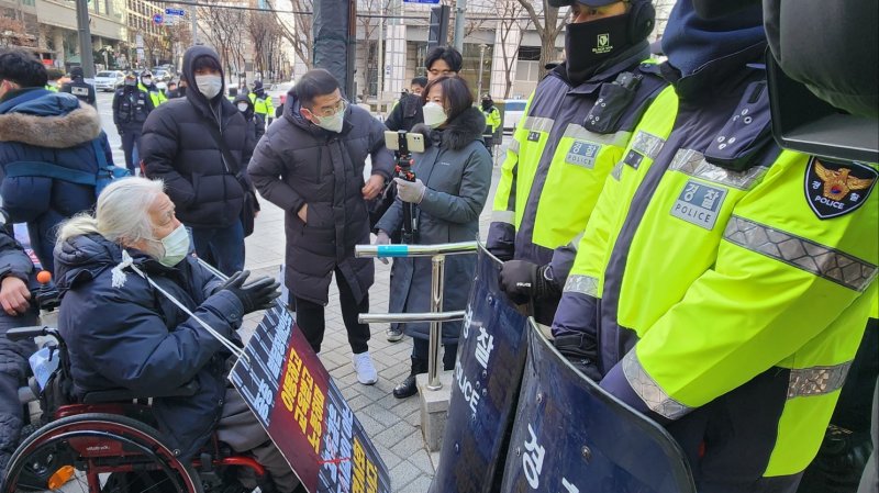 [서울=뉴시스] 이수정 기자 = 전국장애인차별철폐연대 박경석 대표가 14일 오전 서울 종로구 서울경찰청 민원봉사실 앞에서 민원실 진입을 위해 경찰과 대치 중이다. 2022.12.14. crystal@newsis.com /사진=뉴시스