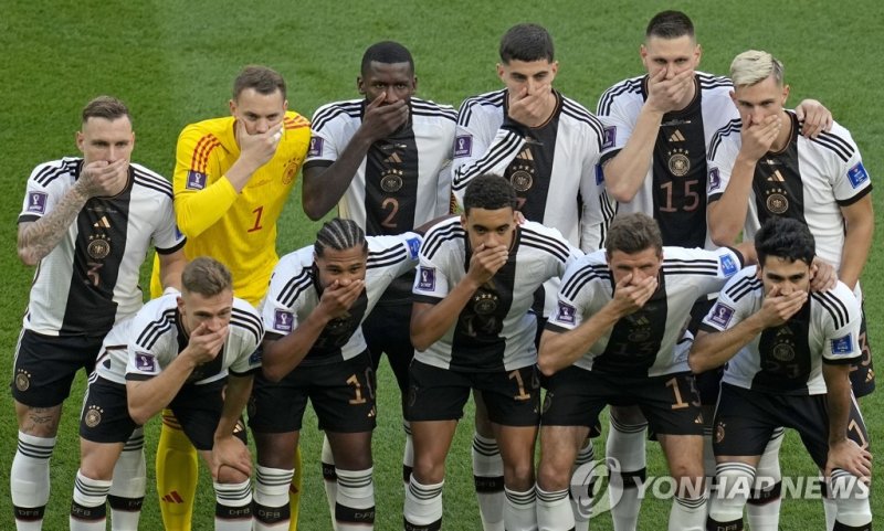 입 가린 독일 대표팀 Germany's soccer team players cover their mouths as they pose for a group photo before the World Cup group E soccer match between Germany and Japan, at the Khalifa International Stadium in Doha, Qatar, Wednesday, Nov. 23, 2022. (AP Photo/Ricardo Mazalan)