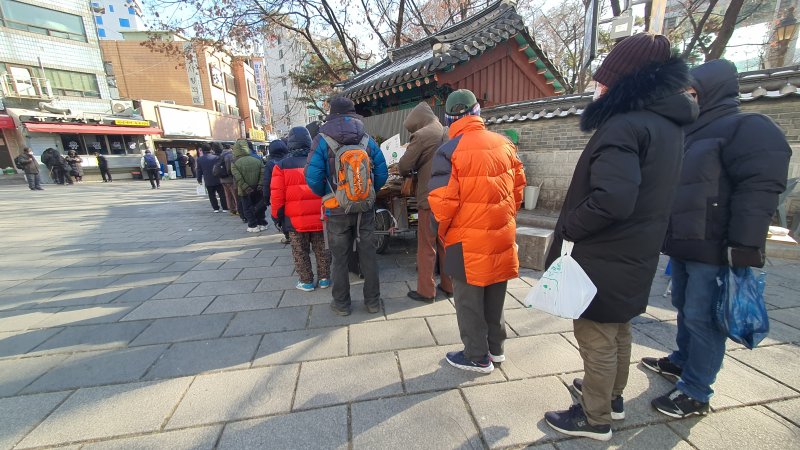 19일 오전 11시 50분께 서울 종로구 탑골공원 인근에서 노인들이 무료 급식을 받기 위해 줄지어 서 있다. 일부는 인근에서 받은 무료 도시락을 들고 추가 급식을 받기 위해 대기하고 있다. 사진=노유정 기자