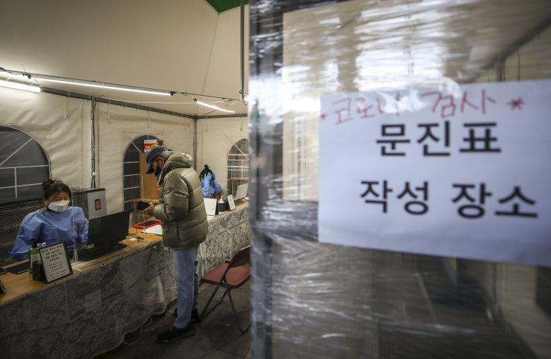 [서울=뉴시스] 정병혁 기자 = 20일 오전 서울 용산구보건소 코로나19 선별진료소를 찾은 시민들이 검사를 받기 위해 문진표를 작성하고 있다. 2022.12.20. jhope@newsis.com