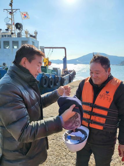 조성대 한국어촌어항공단 상임이사(왼쪽)가 20일 인천 잠진도에서 근로자에게 한랭질환 예방을 위한 보건물품을 전달하고 있다.