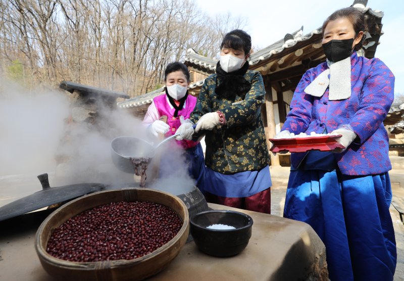 절기상 동지를 이틀 앞둔 20일 오후 경기 용인시 기흥구 한국민속촌에서 직원들이 팥죽을 쑤고 있다. 뉴스1 제공.