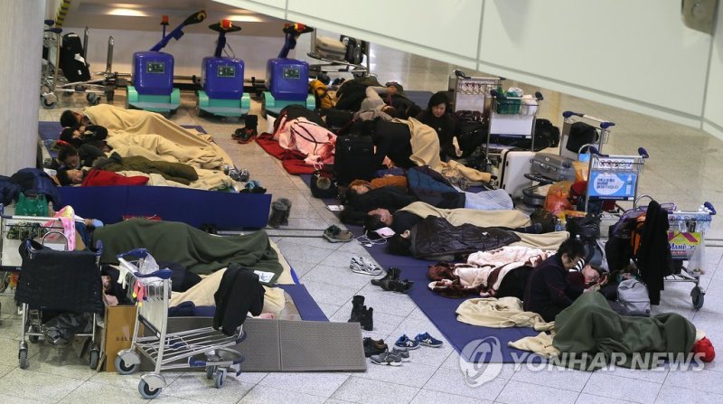 제주국제공항 체류객들의 모습 <최강한파> 긴 하루가 가고 (제주=연합뉴스) 변지철 기자 = 사상 초유의 제주공항 항공기 중단 사태가 3일째 이어진 25일 새벽 고단 하루를 마친 체류객들이 제주공항 여객터미널에서 잠을 자고 있다. 2016.1.25 bjc@yna.co.kr (끝)