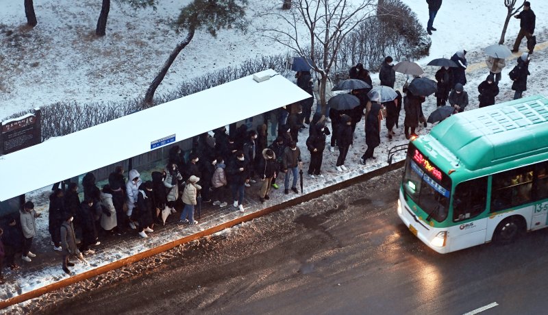 수도권 지역에 대설주의보가 내려진 21일 오전 경기도 수원시 영통구 망포역 버스정류장에서 출근길 시민들이 버스를 기다리고 있다. 뉴시스