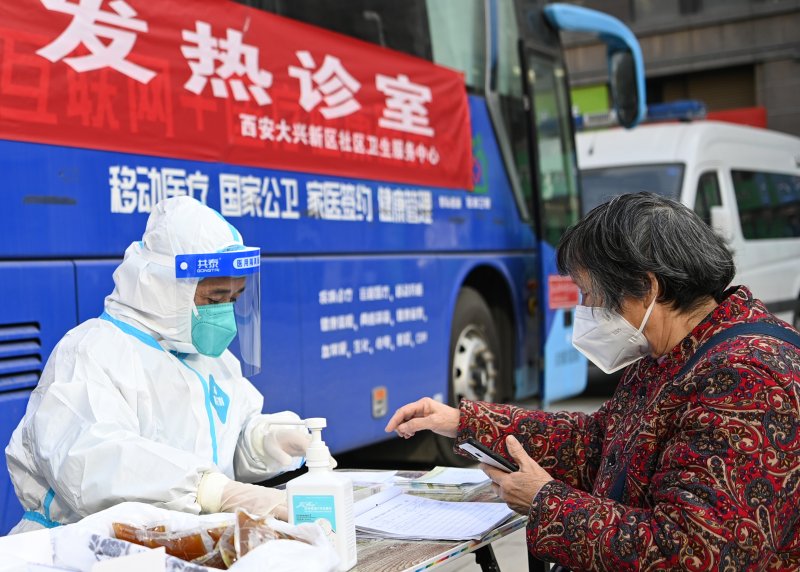 중국 산시성 시안에서 21일 현지 주민이 방역당국 직원에게 코로나19 증상을 상담하고 있다.신화연합뉴스