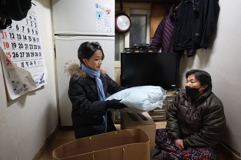 윤석열 대통령 부인 김건희 여사가 22일 2022 찾아가는 성탄절 희망박스 나눔행사를 위해 서울 용산구 남대문쪽방촌을 찾아 어르신에게 겨울 점퍼를 선물하고 있다. (대통령실 제공)