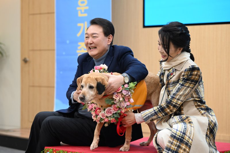 [서울=뉴시스] 윤석열 대통령과 부인 김건희 여사가 24일 경기도 용인 삼성화재 안내견 학교에서 은퇴 안내견 새롬이와 함께 기념촬영하고 있다. (사진=대통령실 제공) 2022.12.24. photo@newsis.com *재판매 및 DB 금지