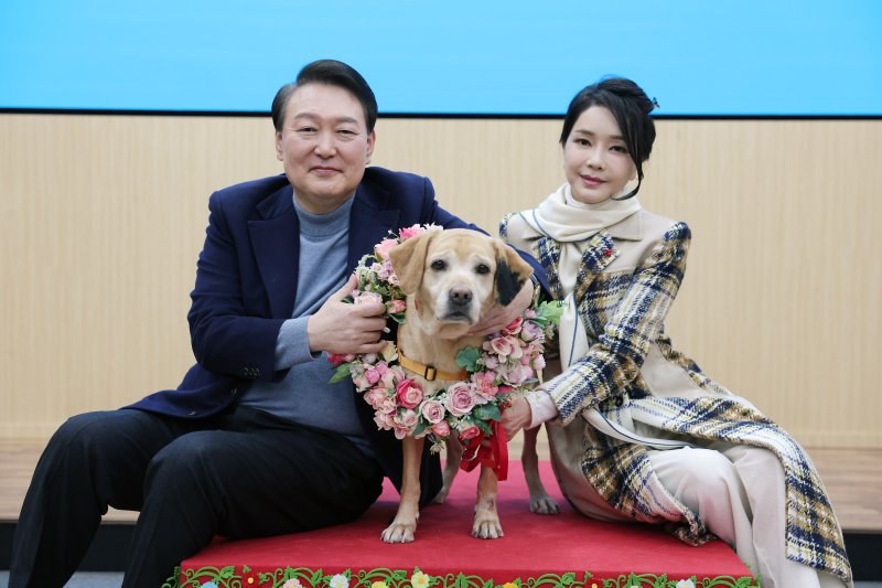 [서울=뉴시스] 윤석열 대통령과 부인 김건희 여사가 24일 경기도 용인 삼성화재 안내견 학교에서 은퇴 안내견 새롬이와 함께 기념촬영하고 있다. (사진=대통령실 제공) 2022.12.24. photo@newsis.com *재판매 및 DB 금지 /사진=뉴시스