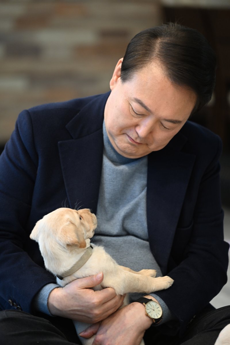 [서울=뉴시스] 윤석열 대통령이 24일 경기도 용인 삼성화재 안내견 학교에서 리트리버 강아지를 안아주고 있다. (사진=대통령실 제공) 2022.12.24. photo@newsis.com *재판매 및 DB 금지