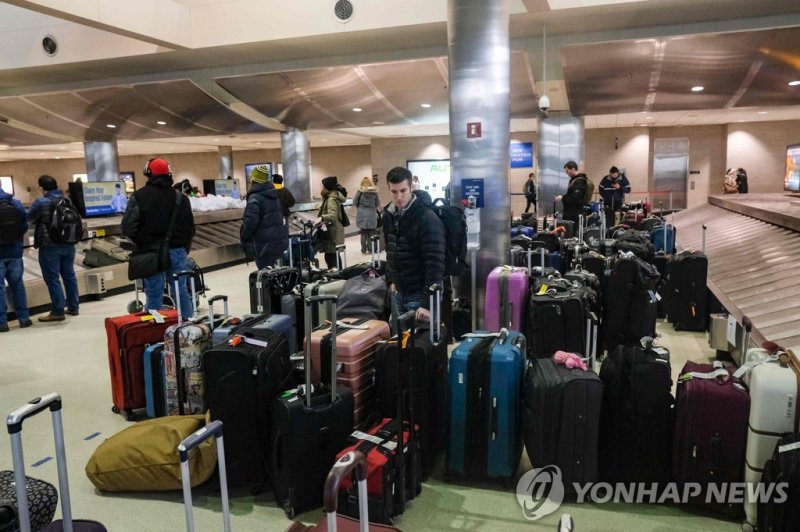 미국 디트로이트 공항 DETROIT, MI - DECEMBER 23: Holiday travelers crowd the Detroit Wayne County Metro Airport on Christmas Eve following Winter Storm Elliot December 24, 2022 in Detroit, Michigan. Winter Storm Elliot swept over much of the midwest on Friday and Saturday, dropping temperatures to single digi