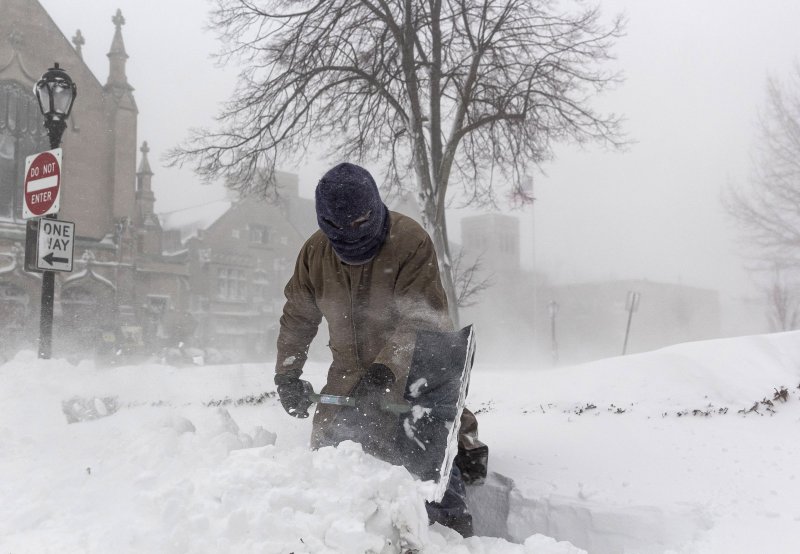 epa10377885 A man shovels a sidewalk during a winter storm affecting large portions of the United States, in Buffalo, New York, USA, 24 December 2022. Much of the United States is experiencing winter weather as result of a large storm generated by a bomb cyclone, the meteorological phenomenon when t