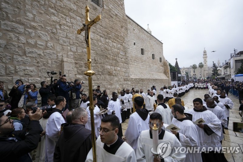 성탄 전야 행사를 위해 예수탄생 교회로 들어서는 사제들. Clergymen and Latin Patriarch Pierbattista Pizzaballa enter the Church of the Nativity, traditionally believed to be the birthplace of Jesus Christ, in the West Bank town of Bethlehem during Christmas, Saturday , Dec. 24, 2022. (AP Photo/Majdi Mohammed)