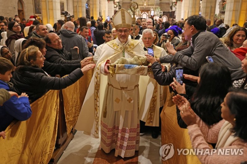 성탄절 자정 미사를 집전하는 피에르바티스타 피자발라 가톨릭교회 예루살렘 대주교. The Archbishop Pierbattista Pizzaballa, apostolic administrator of the Latin Patriarch of Jerusalem leads a Christmas midnight mass at Saint Catherine's Church, in the Church of the Nativity in Bethlehem, in the Israeli-occupied West Bank on December 25, 