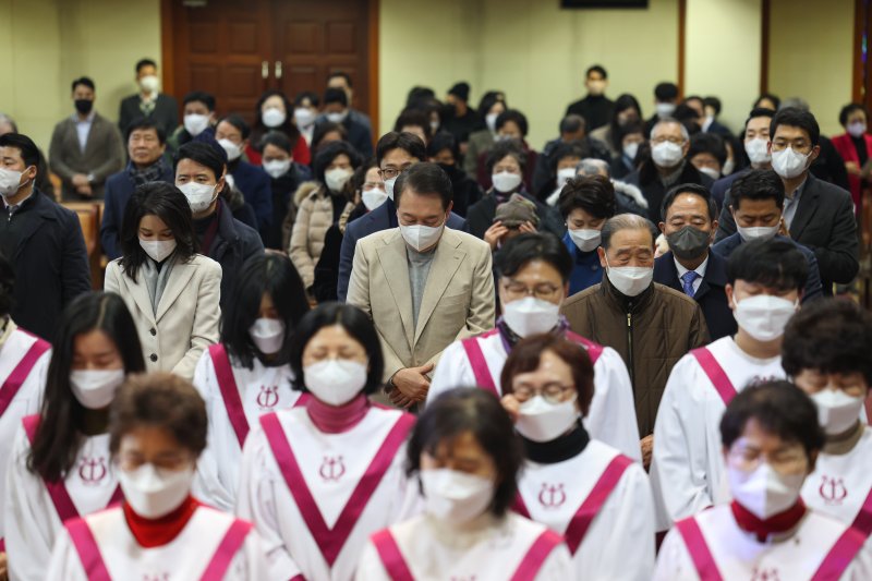 성탄예배 드리는 尹대통령 내외. 윤석열 대통령과 부인 김건희 여사가 성탄절인 25일 서울 성북구 영암교회에서 열린 성탄 예배에서 기도하고 있다. 대통령실에 따르면 영암교회는 윤 대통령이 초등학교 1학년부터 중학교 1학년까지 다녔던 교회다. 대통령실 제공