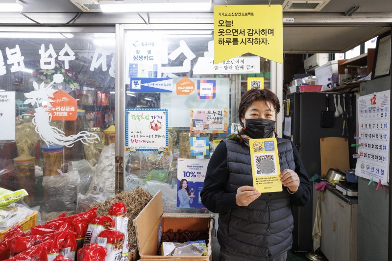 19일 광주 광산구 전통시장 '월곡시장'에서 카카오 소신상인 프로젝트에 참여한 점포 상인이 QR코드를 새긴 인쇄물을 들고 있다.(사진=카카오) *재판매 및 DB 금지