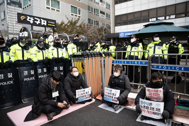 전국민주노동조합총연맹 조합원들이 26일 오전 서울 여의도 더불어민주당 중앙당사 앞에서 ‘노조법 2·3조 개정’ 촉구 피켓을 들고 있다. / 사진=뉴스1