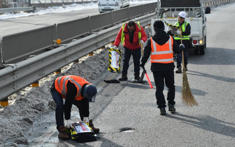[광주=뉴시스] 김혜인 기자 = 26일 오전 광주 광산구 하남진곡산단도로에서 광주시종합건설본부 작업자들이 포트홀(도로 노면 패임)보수 작업을 하고 있다. 2022.12.26.hyein0342@newsis.com