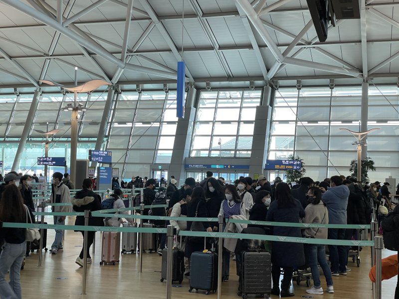 연말연시를 맞아 해외로 나가는 여행객이 급증하고 있다. 26일 인천공항 인천~오사카 노선에 길게 줄 선 승객들. 사진=권준호 기자