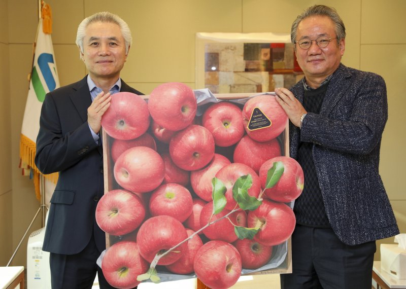 박종복 SC제일은행장이 23일 오전 서울 종로구 SC제일은행 본점에서 뉴스1 사랑의 바자회에서 구매한 그림판화를 강호병 전무이사로부터 전달받은 후 기념촬영하고 있다. 그림판화는 사과전문작가 윤병락 화가의 사과그림 원본을 판화로 재현한 한정판 시리즈 '가을향기 19호'로 서울옥션에서 기증했다. 2022.12.23/뉴스1 ⓒ News1 김도우 기자