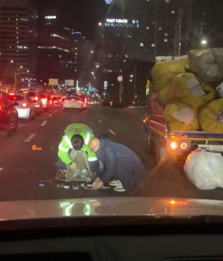 방송인 홍석천이 지난 26일 밤 10시경 서울 마포구 공덕역 부근에서 앞 차량에 실려 있던 쓰레기가 떨어지자 차에서 내려 줍고 있다. 출처=보배드림