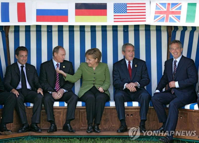 한 자리에 앉은 정상들 epa09618258 (08/26) (FILE) - (L-R) French President Nicolas Sarkozy, Russian President Vladimir Putin, German Chancellor Angela Merkel, U.S. President George W. Bush and British Prime Minister Tony Blair sit underneath their respective national flags in a beach chair during the G8 Summi