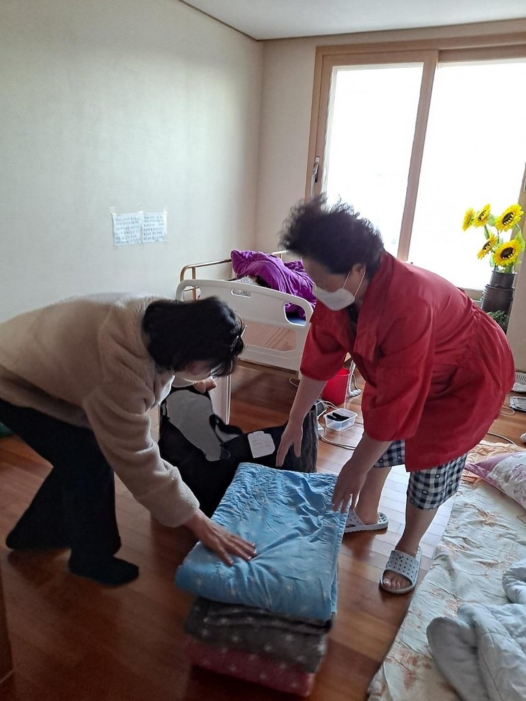 깨끗하게 빤 이불 배달하는 봉사단원 [서산 동문1동 행정복지센터 제공. 재판매 및 DB 금지]