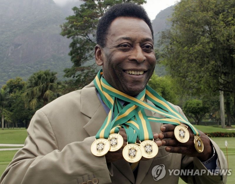 6개의 브라질 1부리그 우승 메달을 목에 걸고 들어보이던 펠레의 모습. (FILES) In this file photo taken on December 22, 2010 Brazilian football legend Edson Arantes do Nascimento, known as 'Pele', poses with his six Brazil's champion medals during a ceremony in Rio de Janeiro, Brazil. - Brazilian football icon Pele, widely regard