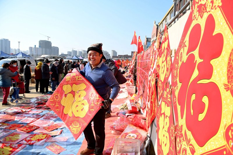 지난 2일 중국 산둥성 칭다오의 한 시장에서 상인이 복이라고 써진 제품들을 들고 선전하고 있다. /AFP연합뉴스