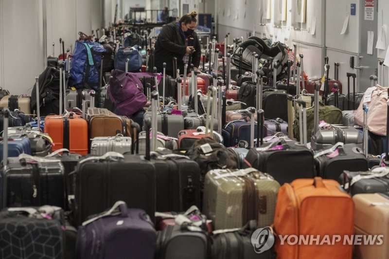 미국을 강타한 겨울 폭풍으로 사우스웨스트 항공편이 대거 지연되거나 결항한 지난해 12월27일(현지시간) 로스앤젤레스 공항에서 사우스웨스트 항공 직원이 여행 가방을 분류하고 있다. 사우스웨스트는 성탄절 당일과 전날 하루 3000편 이상의 운항을 취소한 데 이어 이날도 오전까지 2522편의 운항을 취소했다.<div id='ad_body2' class='ad_center'></div>/사진=연합뉴스