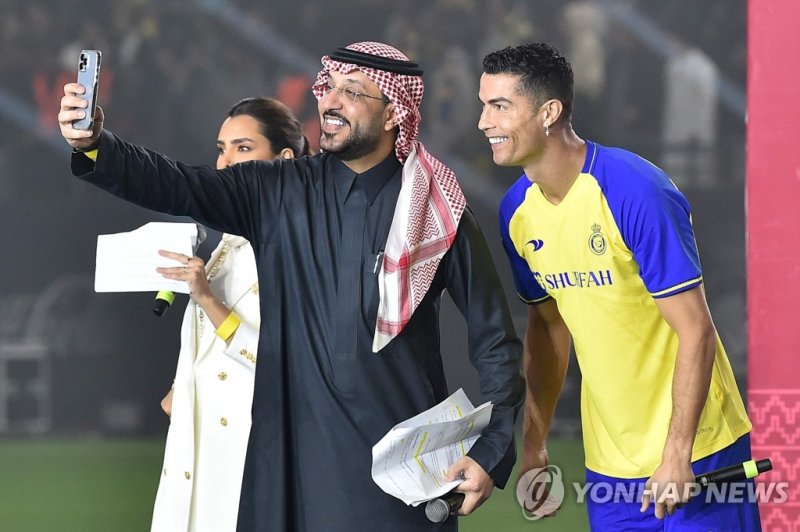 알나스르 입단한 호날두 Al-Nassr's new Portuguese forward Cristiano Ronaldo (R) poses for a selfie with the presenters during his unveiling at the Mrsool Park Stadium in the Saudi capital Riyadh on January 3, 2023. (Photo by AFP)