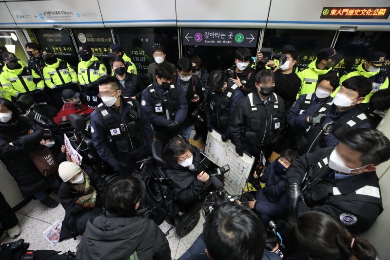 [서울=뉴시스] 조수정 기자 = 지난 3일 오전 서울 지하철 4호선 동대문역사문화공원역 승강장에서 전국장애인차별철폐연대(전장연) 회원들이 254일차 장애인 권리예산 입법 쟁취 지하철 선전전을 위해 탑승하려던 중 저지하는 서울지하철공사 직원 및 경찰들에게 가로막혀 있다. 전장연은 이날 4호선 성신여대입구 역에서 탑승했다가 동대문역사문화공원 역에서 하차했다. 다시 탑승하고 삼각지역으로 향해 집회를 이어가려고 했으나 교통공사와 경찰의 탑승 저지로 이동하지 못하고 있다. 2023.01.07. chocrystal@newsis.com /사진=