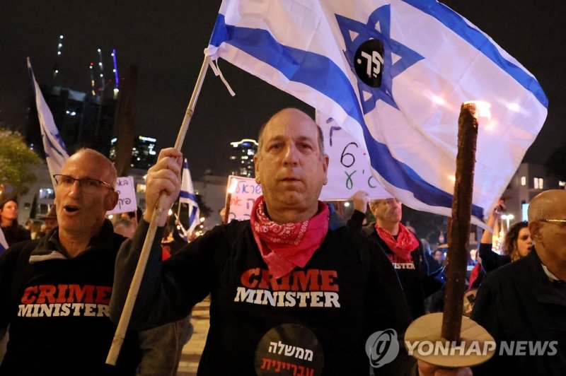 이스라엘 텔아비브에서 열린 반정부 시위. Israeli left wing protesters march with torches during a really against Israel's new hard-right government led by Prime Minister Benjamin Netanyahu, on January 7, 2023 in Tel Aviv. (Photo by JACK GUEZ / AFP)
