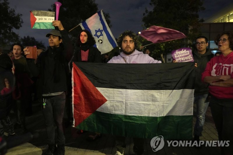 이스라엘 텔아비브에서 열린 반정부 시위에 등장한 팔레스타인 깃발. A protester holds a Palestinian flag in Tel Aviv, Israel, at a demonstration against Prime Minister Benjamin Netanyahu's far-right government, Saturday, Jan. 7, 2023. Thousands of Israelis protested plans by Netanyahu's government that opponents say threaten demo