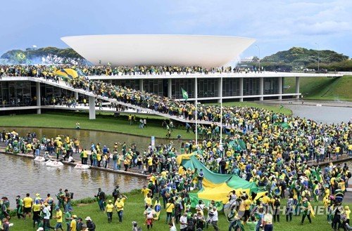 브라질 의회 건물을 향하는 보우소나루 전 대통령 지지자들 (브라질리아 AFP=연합뉴스) 8일(현지시간) 브라질 수도 브라질리아 의회 건물에 자이르 보우소나루 전 대통령 지지자들이 몰려들고 있다. 2023.1.9