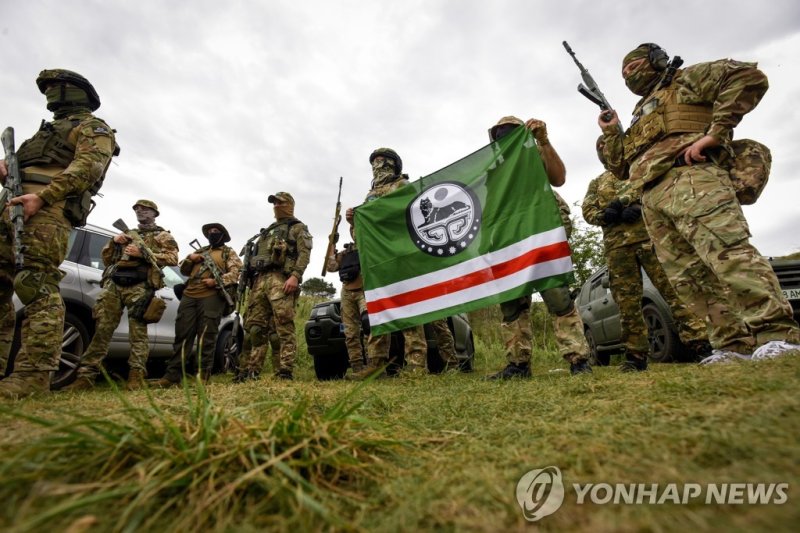 "러시아에 복수를" 우크라 전쟁에 뛰어든 주변국 자원자들 epa10141429 Volunteers in the Dzhokhar Dudayev Battalion pose with a flag of the so-called Chechen Republic of Ichkeria with Coat of Arms, during an exercise at an undisclosed location in the Kyiv area, Ukraine, 28 August 2022. The battalion is made up mostly of Chech