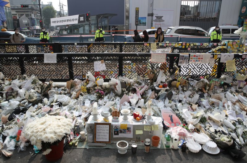 서울 용산구 이태원역 1번출구에 마련된 참사 희생자 추모공간을 지나는 시민들이 추모를 하고 있다. / 사진=뉴시스