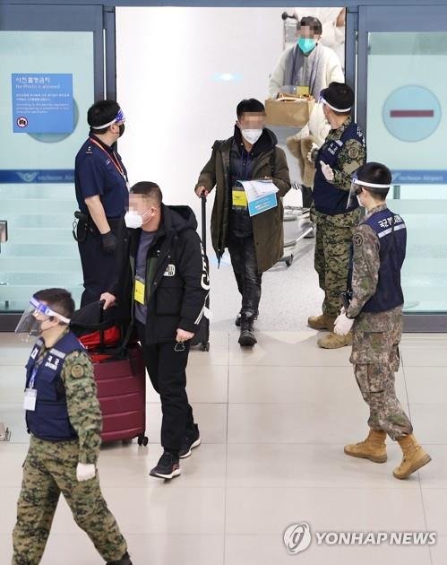 노란색 비표 착용한 채 이동하는 중국발 입국자들 (영종도=연합뉴스) 김도훈 기자 =8일 오후 인천국제공항 제1여객티미널을 통해 입국한 중국발 입국자들이 검역지원단의 안내를 받아 이동하고 있다. 2023.1.8 superdoo82@yna.co.kr (끝)