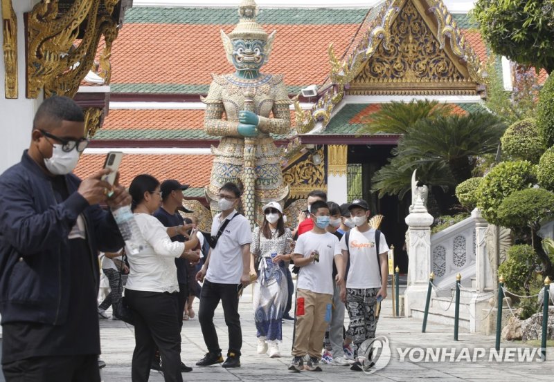 epa10397722 Chinese tourists visit the Temple of the Emerald Buddha, one of Bangkok's most popular tourist attractions, in Bangkok, Thailand, 10 January 2023. Thailand welcomed the return of Chinese tourists without special COVID-19 health restrictions, aimed to boost the country's economy and recov