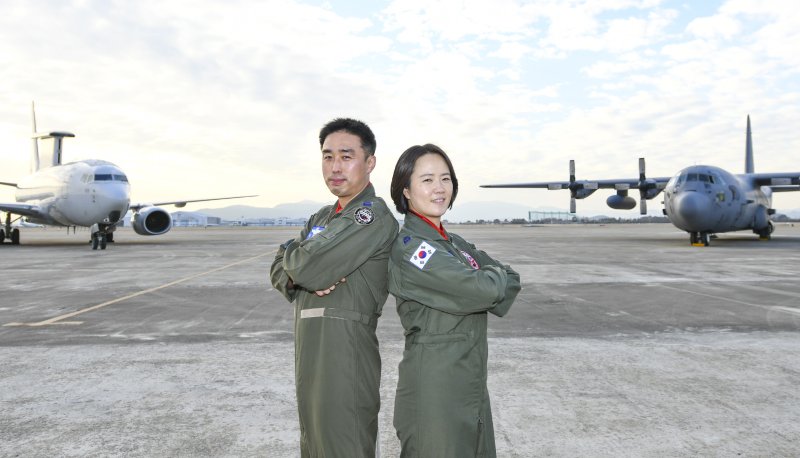 공군 첫 비행대대장 부부인 김익규(왼쪽)·김민지 중령이 각각 대대장으로서 지휘하는 E-737 항공통제기와 C-130 수송기를 배경으로 포즈를 취하고 있다. 사진=제5공중기동비행단 제공