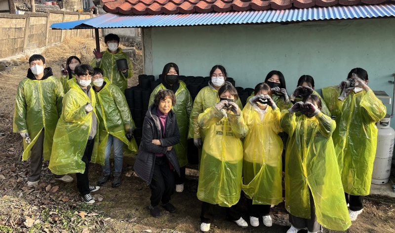 ‘동계 청소년 자원봉사학교’에 참가한 청소년들이 연탄 배달 후 사진을 찍고 있다. (계룡시 제공)