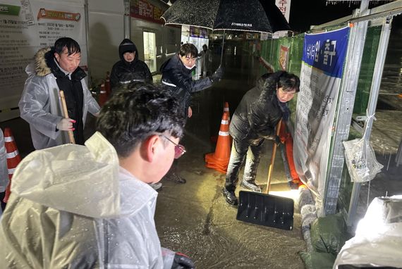 최문순 화천군수가 13일 새벽 폭우가 내리자 산천어축제장에서 빗물을 퍼내고 있다. (사진=화천군)