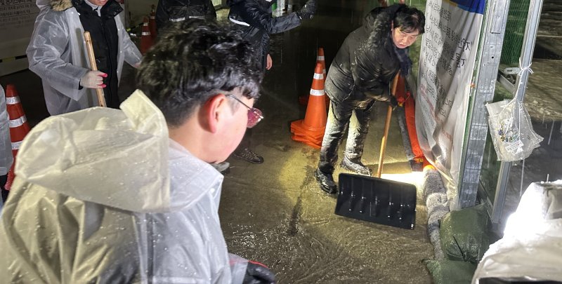 최문순 화천군수를 비롯 군청 직원들이 13일 새벽 화천산천어축제장 주변에서 빗물제거 작업을 펼치고 있다..(화천군 제공) 2023.1.13/뉴스1